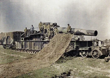 Acht Franse soldaten camoufleren een 370 mm spoorwegkanon met de inscriptie Keity, Noyon, Oise, Frankrijk, 5 september 1917